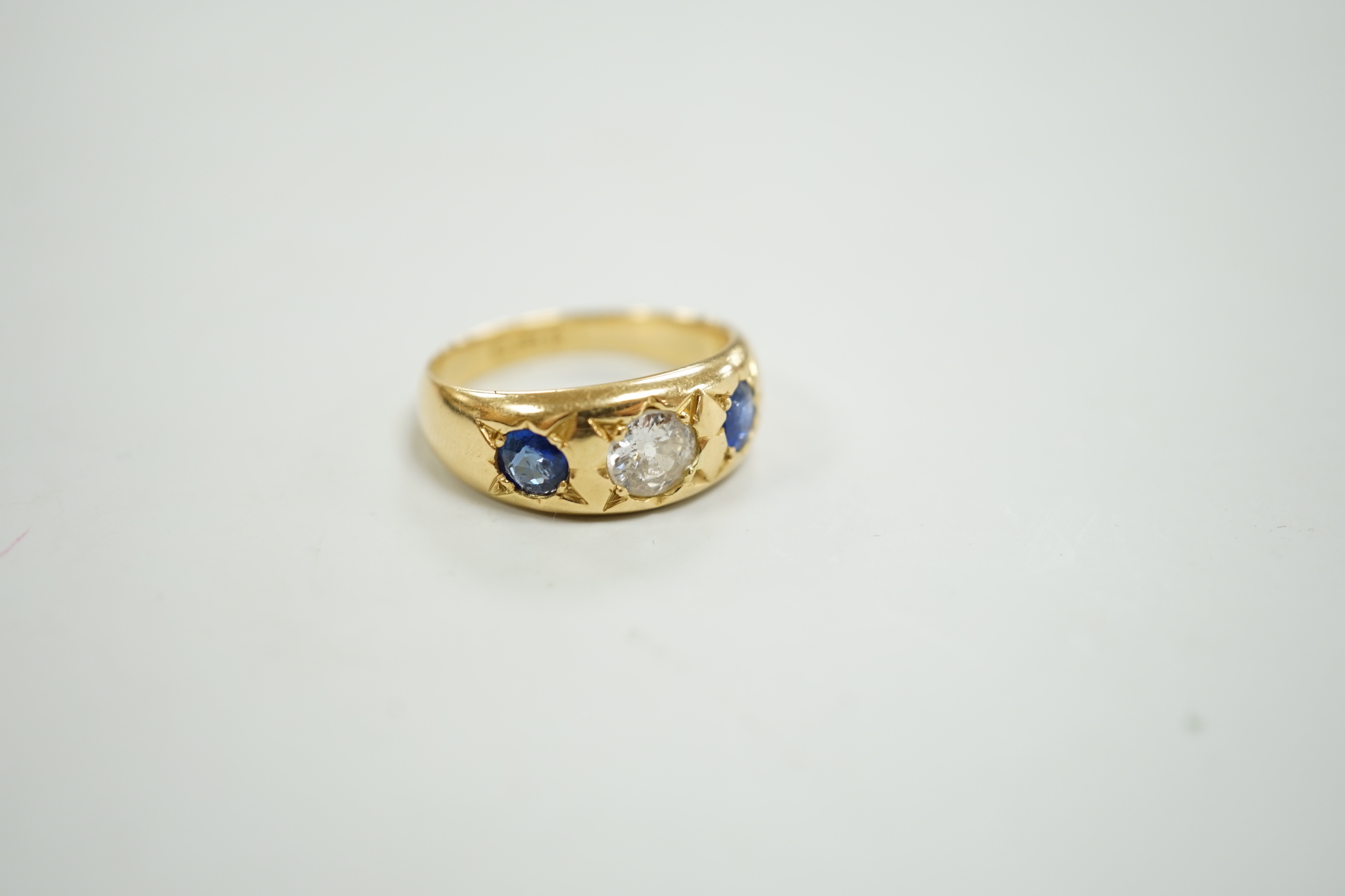 An early 20th century 18ct gold and gypsy set single stone diamond and two stone sapphire set ring, size O, gross weight 6.4 grams.